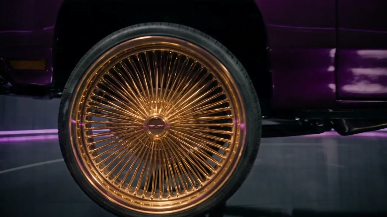 Close view of a 26-inch gold wire-spoke wheel on the E1.